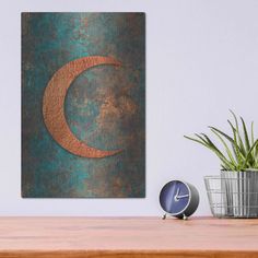 a clock sitting on top of a wooden table next to a potted green plant