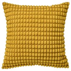 a yellow pillow that is made out of wool and has small circles on the front