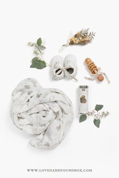 the contents of a scarf laid out on a white surface with leaves and other items