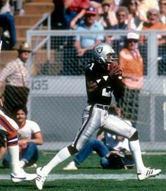 a football player holding a ball in his hands while standing next to other players on the field