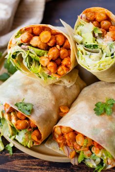 several wraps filled with chickpeas and lettuce on top of a plate