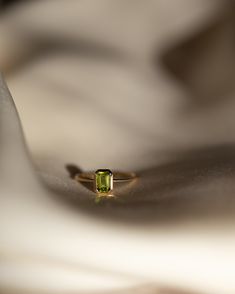 The octagon-shaped peridot on this ring is both eye-catching and elegantly simplistic. It is the perfect way to celebrate a special August birthday or simply adorn oneself with its stunning light green hue. Metrical : 14-karat Yellow Size: Band measures 1mm, Peridot measures 6x4mm Dainty 14k Gold Emerald Cut Birthstone Ring, Dainty 14k Gold Birthstone Ring With Emerald Cut, Dainty Emerald Cut Solitaire Birthstone Ring, Minimalist Emerald Cut Birthstone Ring With Bezel Setting, Minimalist May Birthstone Ring With Emerald Cut, Minimalist Emerald Cut May Birthstone Ring, Minimalist 14k Gold Emerald-cut Birthstone Ring, Minimalist 14k Gold Emerald Cut Birthstone Ring, Emerald Cut Peridot Ring For May Birthstone