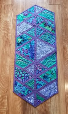 a purple and blue quilt on the floor