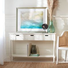 a white console table with two vases and a painting on the wall behind it