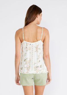 An ultra-pretty lace-trimmed camisole designed in an ivory and pink floral print. Floral print Relaxed fit Sleeveless Hip length V-neckline Ruffle hemline Lace trim Adjustable spaghetti straps Spring floral camisole It doesn't get much cuter than this flowy floral print camisole with delicate lace trim details. Featuring a flirty ruffle hem, this romantic bohemian top can be styled casually with your favorite pair of jeans or dressed up for date nights. Model is 5'9, wearing a size XS.Style: I-1 Spring Delicate Lace Tank Top With Spaghetti Straps, Spring Delicate Lace Sleeveless Camisole, Spring Sleeveless Camisole With Delicate Lace, Delicate Lace Sleeveless Camisole For Spring, Cream Camisole With Adjustable Spaghetti Straps, Spring Feminine Lace Trim Camisole, White Floral Print Cami Tank Top, Feminine Spring Camisole With Lace Trim, Feminine Lace Trim Camisole For Spring