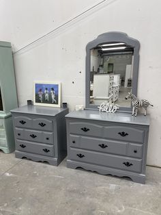 two grey dressers with zebra figurines on top and one in the mirror