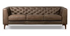 a brown leather couch sitting on top of a white floor