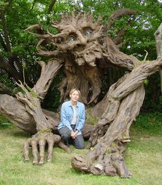 a woman sitting in front of a tree stump