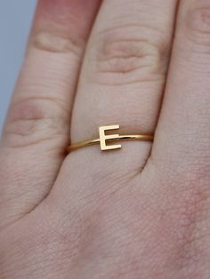 This elegant gold initial ring is perfect for stacking, making it a great gift for any occasion - whether a mother's day surprise or a best friend's birthday present. Crafted from quality stainless steel, this letter ring will look beautiful for years to come. Featuring a letter of your choosing, this ring can be worn alone or stacked making it perfect for gifting to friends or family. The subtle, yet sweet letter ring looks elegant alone or as part of a larger stack. This gold letter ring is th Simple Personalized Initial Ring For Everyday, Everyday Personalized Yellow Gold Initial Ring, Personalized Yellow Gold Initial Ring For Everyday, Minimalist Monogram Initial Ring, Everyday Gold Rings With Custom Name, Everyday Gold Ring With Custom Name, Everyday Custom Name Gold Ring, Everyday Gold Stackable Rings With Initials, Gold Stackable Rings With Initials For Everyday