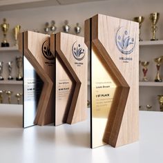 three wooden trophies are displayed on a table