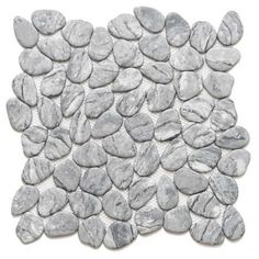 a pile of rocks sitting on top of a white flooring tile covered in grey stones