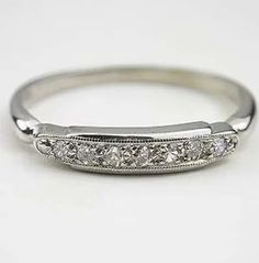 an antique style wedding band with five diamonds on the side, set in 18k white gold