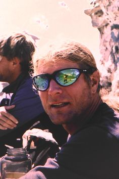 two men sitting next to each other wearing sunglasses