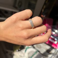 a person's hand with a wedding ring on top of their finger in front of some other items