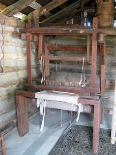 an old fashioned weaving machine in a log cabin