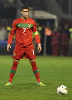 a soccer player standing next to a ball on a field