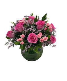 a vase filled with pink roses and greenery