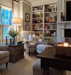 a living room filled with furniture and a fire place in front of a book shelf