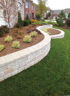 a stone retaining wall in front of a house