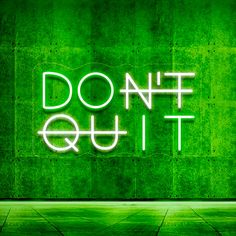 a neon sign that says don't quit out on the side of a wall