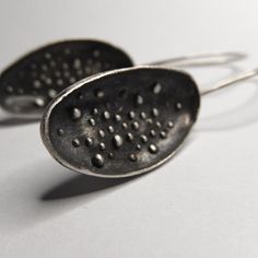 These wonderful earrings made in sterling silver have a modern contemporary design and a satin-matte finish. ► DESCRIPTIONS and MEASUREMENTS: Handmade from 925 sterling silver. This is a cast jewelry The earrings have a free oval shape with granulations (dots) on the inside of the oval. The ear wires are hammered at the front for more elegance. I gave the earrings a dark patina and then polished the top of the dots to emphasize the design. Oval shape size: 2.7 x 1.4 cm Earrings total height: 5.3 Contemporary Earrings With Oxidized Finish, Contemporary Earrings With Oxidized Finish As Gift, Contemporary Sterling Silver Earrings With Oxidized Finish, Contemporary Oxidized Finish Earrings For Gift, Contemporary Oxidized Finish Earrings, Contemporary Silver Drop Earrings, Contemporary Silver Earrings With Oxidized Finish, Contemporary Teardrop Sterling Silver Earrings, Modern Sterling Silver Earrings With Oxidized Finish