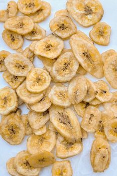 a pile of sliced bananas sitting on top of a white tablecloth covered in brown stuff