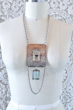 This is one of the most special pieces of jewelry to the shop in a while. Made entirely from repurposed sterling silver components, this necklace centers around a gorgeous antique sterling floral belt buckle. It is set with texture vintage sterling chain, and hanging from the center, a large emerald cut pale blue stone pendant, likely an aquamarine. This piece is full of vintage glamour, a modern day heirloom.  All pieces are unique. They are made completely from found and recycled parts, much like found-object art. I have loved jewelry my whole life. I want to create pieces that drape and lay on the body the way clothing would, using relics and totems from years past. Jewelry you'd see a rockstar wear... Jewelry that requires guts, soul, and thought... www.reckless-daughter.com Silver Jewelry With Soldered Square Pendant, Silver Square Pendant Jewelry With Soldered Details, Silver Square Pendant Jewelry, Sterling Silver Pendant For Vintage Collection, Vintage Square Pendant Jewelry Engraved, Elegant Sterling Silver Jewelry With Vintage Charm, Vintage Engraved Square Pendant Jewelry, Antique Sterling Silver Jewelry From Vintage Collection, Antique Sterling Silver Jewelry For Vintage Occasions