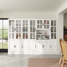 a large white bookcase in the middle of a room with chairs and a table