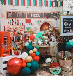 there is a pizza stand with balloons and other items