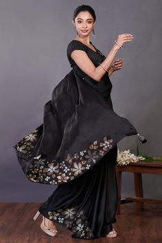 Beautiful black Swarovski floral motifs satin saree. It comes with a matching saree blouse. Shop designer saris online in USA from Pure Elegance. Disclaimer: The actual product may vary slightly from the image. These are custom orders, hence expect slight variation in color, placement of the motif or buta. ESTIMATED DELIVERYBecause this is a custom order, it would take about 4 weeks from the date of purchase. RETURN POLICYThis product is a custom order and cannot be returned or exchanged. Black Silk Bollywood Saree, Black Silk Bollywood-style Saree, Bollywood Style Black Silk Saree, Black Silk Blouse Piece With Zari Work, Black Silk Saree With Zari Work, Designer Black Katan Silk Blouse Piece, Black Katan Silk Blouse For Designer Wear, Black Art Silk Saree For Wedding, Designer Art Silk Black Blouse Piece