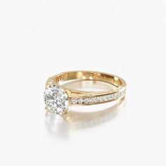 a yellow gold engagement ring set with a round diamond and channeled diamonds on the band