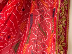 Very beautiful and gorgeous light weight red Georgette tie dye bandhej chunri with zari work. It is decorated with golden flower embroidered lace on all 4 sides. This is a ready to wear dupatta/scarf. It can be used for wedding, wedding rituals, party, bridesmaid gift, lehenga dupatta, Indian functions or events. Dimension: Length: 2 meter Width: 1.2 meter Bohemian Choli With Bandhani Print In Chanderi, Bohemian Bandhani Print Choli In Chanderi, Bohemian Chanderi Choli With Bandhani Print, Bandhani Print Saree For Festival, Chanderi Traditional Wear With Bandhani Print For Festivals, Festival Chanderi Traditional Wear With Bandhani Print, Red Bollywood Choli With Bandhani Print, Festival Chanderi Bandhani Traditional Wear, Red Traditional Wear With Pallu For Festival