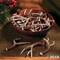 a wooden bowl filled with antlers on top of a table