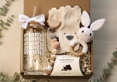 an open box containing items from the caramel's baby essentials range on a table