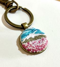 a close up of a keychain with a small object on it's side