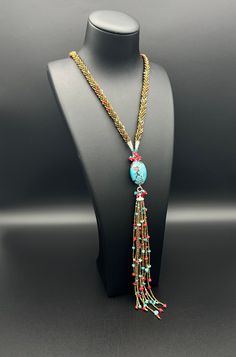 a necklace on a mannequin with beads and tassels hanging from it