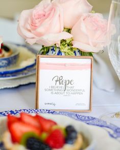 a table topped with plates and cups filled with fruit next to flowers on top of each plate