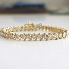 This diamond s link tennis bracelet is a classic staple for any jewelry collection! The diamonds are set in 18k yellow gold and circle the entire bracelet. Metal: 18K Yellow Gold Diamonds: 2.25 CTW SI2-I1 G-H Length: 7.25 For a greater selection of jewelry please visit our website at www.BlackMarketLLC.com If you have any questions about this product or if we can help you with any of our other products please contact us through Etsy or our website at www.BlackMarketLLC.com Each piece of our jewe Formal Yellow Gold Tennis Bracelet With Single Cut Diamonds, Classic Yellow Gold Diamond Cut Diamond Bracelet, Classic Yellow Gold Diamond Cut Bracelet, Classic Diamond Gold Bracelet For Anniversary, Timeless Diamond Gold Bracelet For Anniversary, Fine Jewelry Diamond Gold Bracelet For Anniversary, Classic Gold Diamond Bracelet With Round Cut, Classic Round Gold Bracelet With Diamonds, Classic Diamond Bracelet For Anniversary