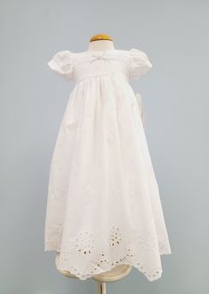 Brooke Christening Dress This sweet little dress is made from 100% cotton in an adorable eyelet design. It has an empire waistline, back pearl button closure with a bow. Perfect to be worn as a Girls Christening dress or a Baby Blessing Dress. Includes a matching bonnet. Hand wash, hanger dry. Made in the USA. SKU#6512 Size Information Comes in 0/3 Month size for 7-14 pounds. 3/6 is for babies who wear size 6 month size. and 6/12 Months. Fitted Cotton Eyelet Dress, Cotton Dresses For First Communion In Spring, Spring Baptism Cotton Dress, Fitted Cotton Broderie Anglaise Dress, Spring Baptism Dress With Fitted Bodice, Cute Fitted Dress For First Communion, Cotton Short Sleeve Dress For Baptism, Classic Cotton Dresses With Buttons, Classic Cotton Dress With Buttons