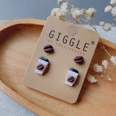 the earrings are made out of wood and have shells in them on top of a wooden tray