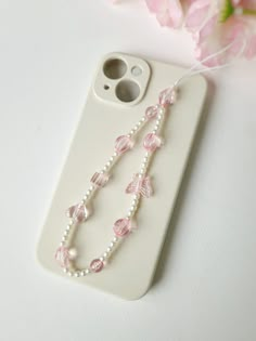 Add a touch of whimsy to your phone with our charming beaded phone strap. Crafted with delicate small pearls and accented with adorable pink butterfly and heart beads, this phone charm is the perfect blend of elegance and fun. Designed to be both stylish and functional, it can be used as a phone chain, keychain, or bracelet. This delightful accessory is ideal for adding a unique flair to your phone and makes a thoughtful gift for any occasion. Iphone Keychain Beads, Pink Phone Strap, Phone Chain Beads, Pink Phone Charm, Pearl Phone Charm, Butterfly And Heart, Beaded Phone Strap, Phone Keychain, Homemade Necklaces