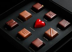 there are many different types of chocolates in the box with red heart on top