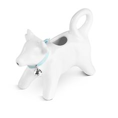 a white dog figurine with a bell on it's neck and collar