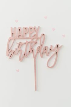 a pink happy birthday cake topper on a white background