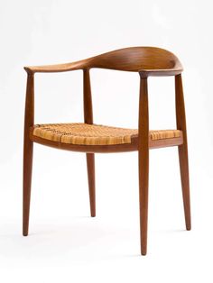 a wooden chair with wicker seat and armrests on the back, against a white background