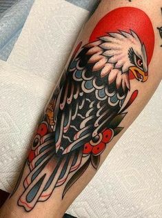 an eagle tattoo on the arm with red and blue colors in it's wings