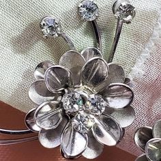 "A beautiful pair 1950's era clip-on earrings, a flower with rhinestones in silver tone. Well made with good tension on the backs, they are in good condition with some wear to silver on back, rhinestones are secure, MEASURES: 1- 1/8\"H Items are vintage, used NOT new or in perfect condition. PLEASE BE SURE TO REVIEW measurements, pictures, description & shop policies in full. I LOVE Etsy. My goal is to satisfy all of my customers, item is not in new condition, sales are final, I generally do Vintage Flower Jewelry For Party, Silver Vintage Flower Earrings For Formal Occasions, Vintage Flower Earrings For Wedding, Vintage Flower Earrings For Party, Vintage Flower Shaped Jewelry For Party, Vintage Flower Earrings For Anniversary, Silver Vintage Flower Earrings For Anniversary, Vintage Flower Shaped Earrings For Anniversary, Rockabilly Costume