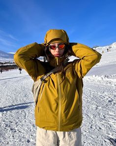 a woman in yellow jacket standing on snow covered ground