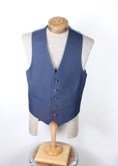 "ALL CLOTHING SALES ARE FINAL. How sharp is this vest, though? Wow. Navy polyester 5-button with perfect fit back. Back has satin coin pattern material. No smoke, mildew or damage. Please check measurements before purchasing. Measurements:  Chest: 34\" Length: 23\" Pair with many of the handsome ties available in the shop right now and save on shipping! I'm here to make you look good. What a fun item! Thank you for looking!" Tailored Sleeveless Vest With Button Closure, Fitted Vest With Snap Buttons For Work, Tailored Sleeveless Vest With Buttons, Formal Sleeveless Vest With Button Closure, Fitted Blue Denim Vest With Snap Buttons, Blue Fitted Denim Vest With Snap Buttons, Sleeveless Vest With Button Closure For Tailoring, Fitted Sleeveless Sweater Vest With Button Closure, Fitted Sleeveless Vest With Pockets