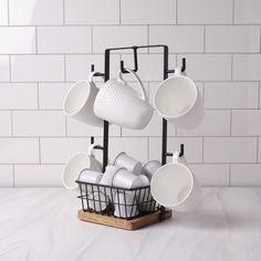 a rack with cups and saucers on it in front of a white tiled wall